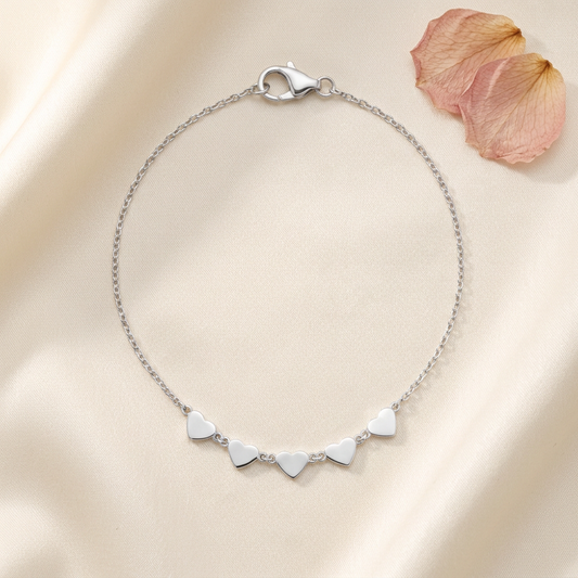 The Beloved Silver Bracelet flatlay on cream silk with rose petals
