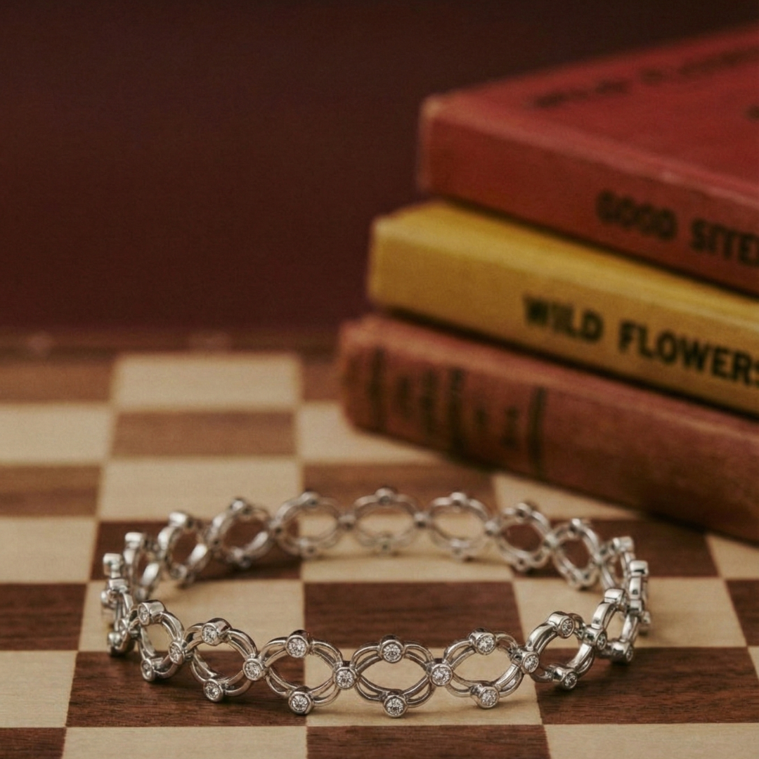 Silver bracelet on a checkered surface with books in the background