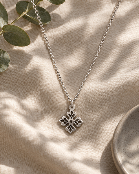 Enchanted Clover Silver Pendant on pale linen with eucalyptus