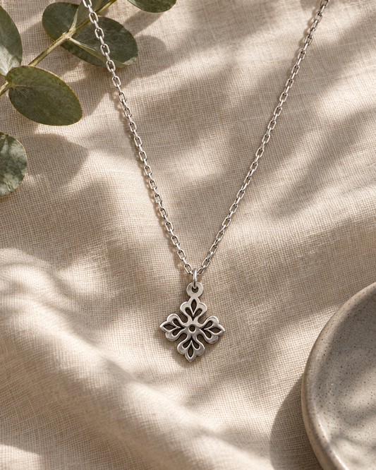 Enchanted Clover Silver Pendant on pale linen with eucalyptus